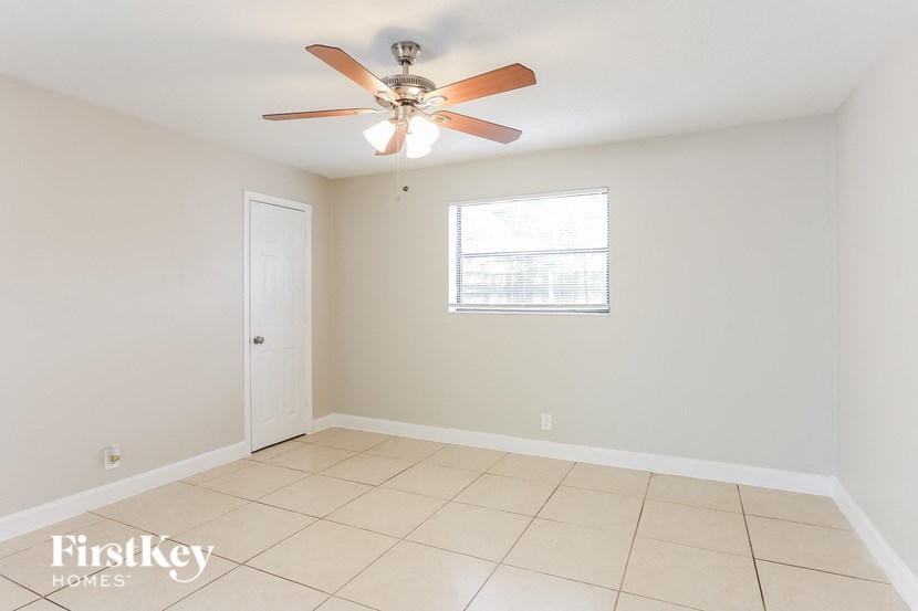 A room with a ceiling fan and a window.