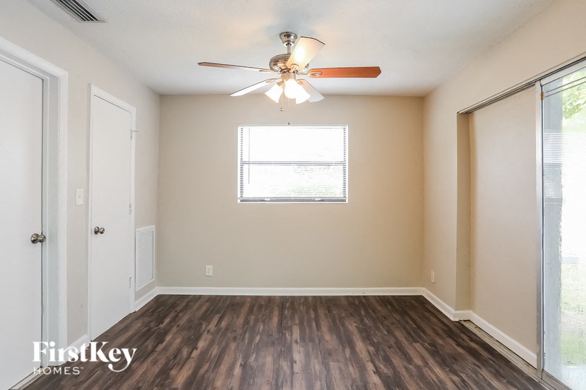 A room with a ceiling fan and a window.