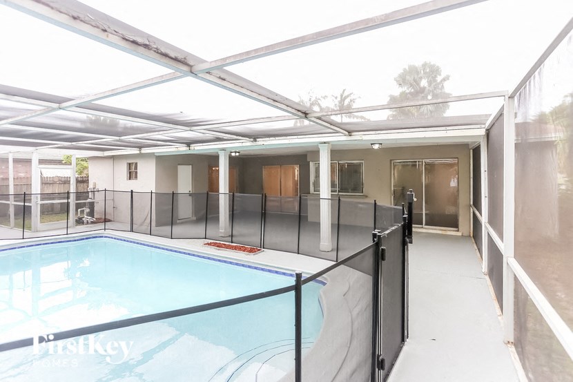 A pool inside a house with a glass fence around it.