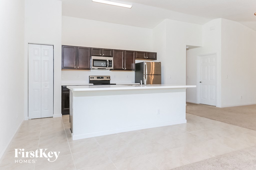 an empty kitchen with a counter top and a refrigerator