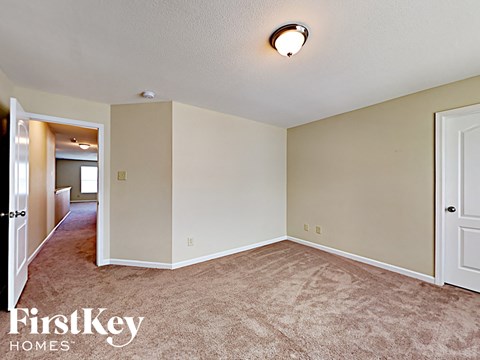 A carpeted room with a FirstKey Homes logo.