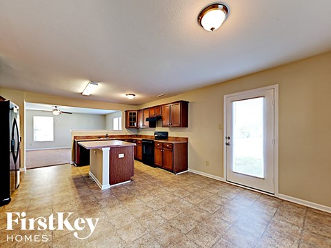A kitchen with a tile floor and a ceiling fan.