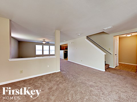 A spacious room with a staircase leading to the upper floor.