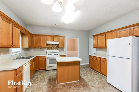 A kitchen with wooden cabinets and a white refrigerator.