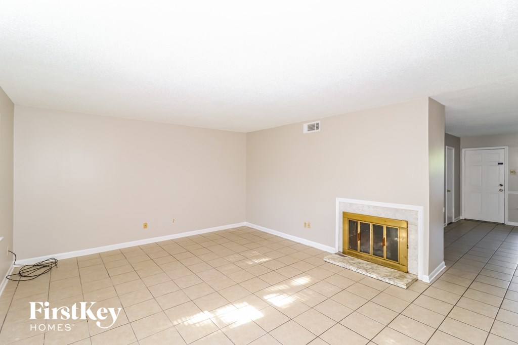 a living room with a fireplace and a tiled floor