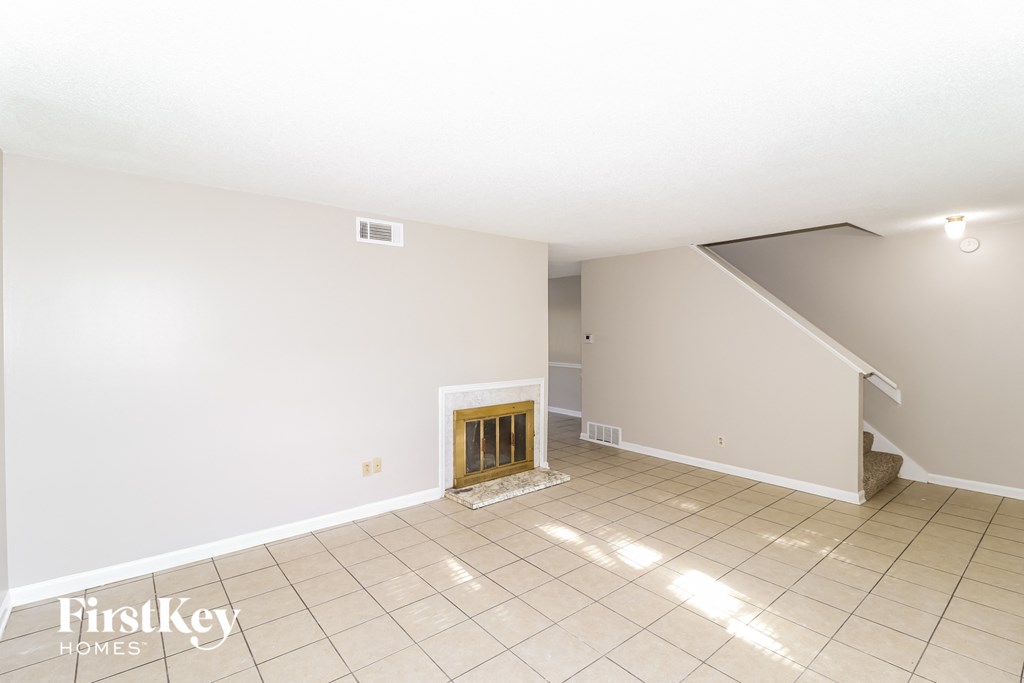 a living room with a fireplace and a tiled floor