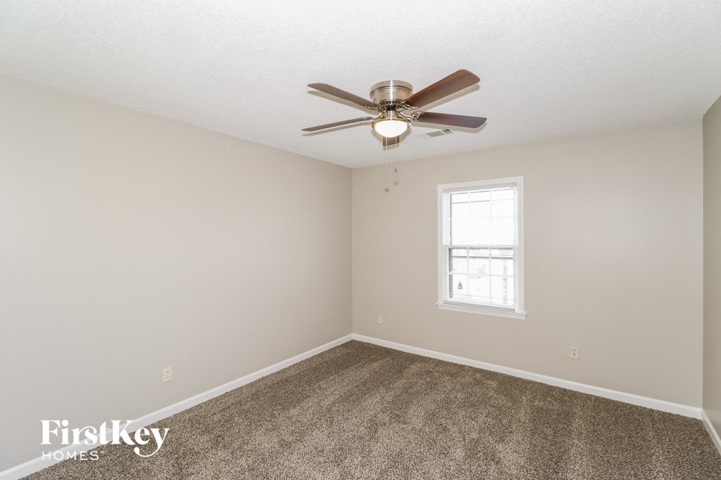 a bedroom with carpet and a ceiling fan