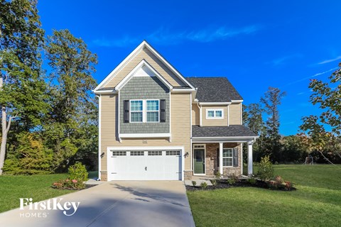 a single story home with a garage on a lawn