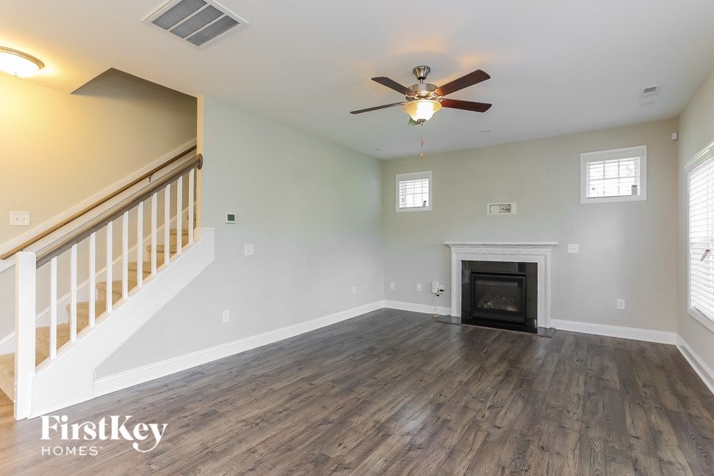 a living room with a fireplace and a ceiling fan
