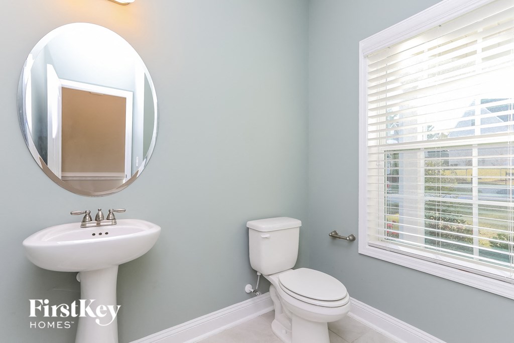 a bathroom with a toilet and a sink and a mirror