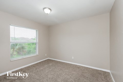 the second bedroom has carpet and a large window