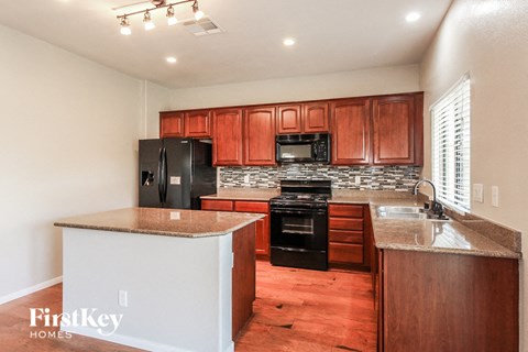 A kitchen with wooden cabinets and black appliances.