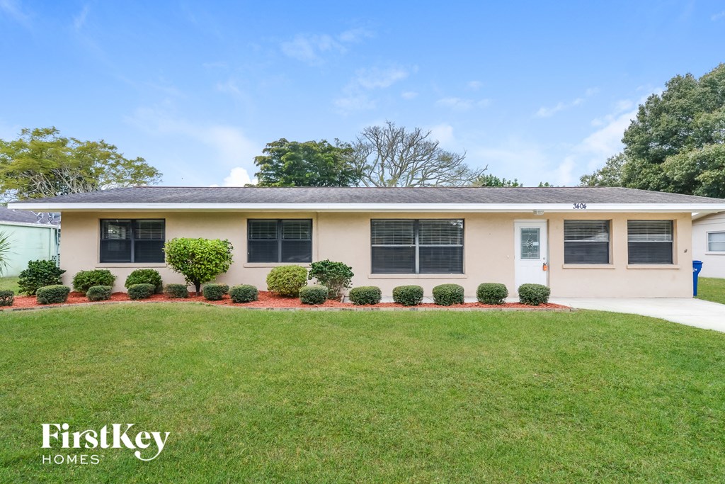 A house with a lawn and a sign that says FirstKey Homes.