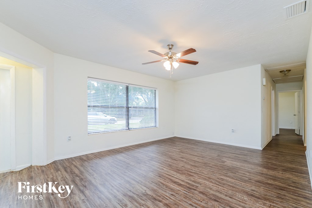 A room with wooden flooring and a ceiling fan.