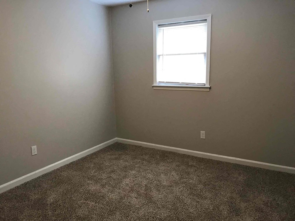 a empty room with a window and carpet
