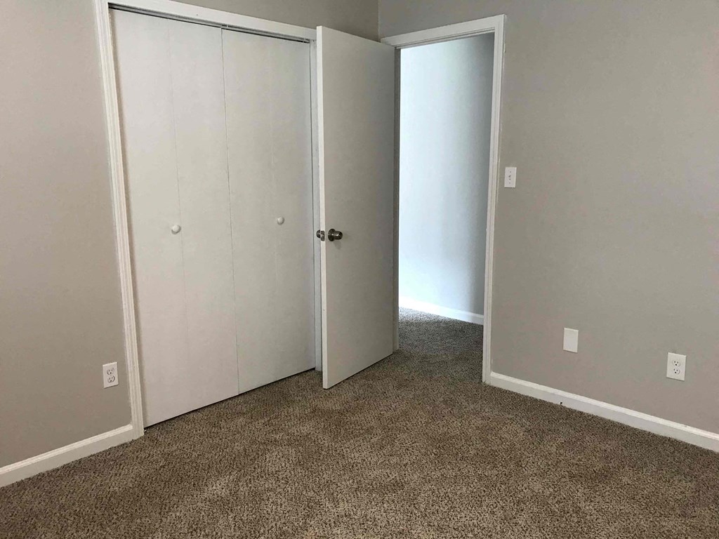 an empty room with two closets and a carpet