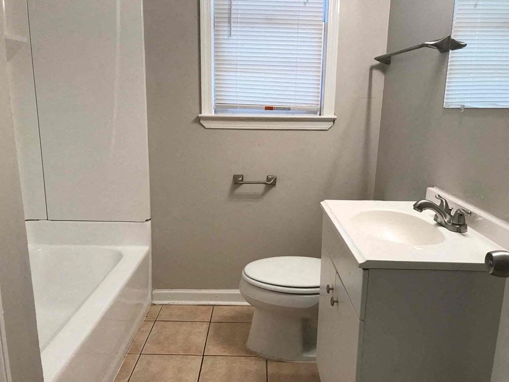 a bathroom with a toilet and a sink and a bath tub