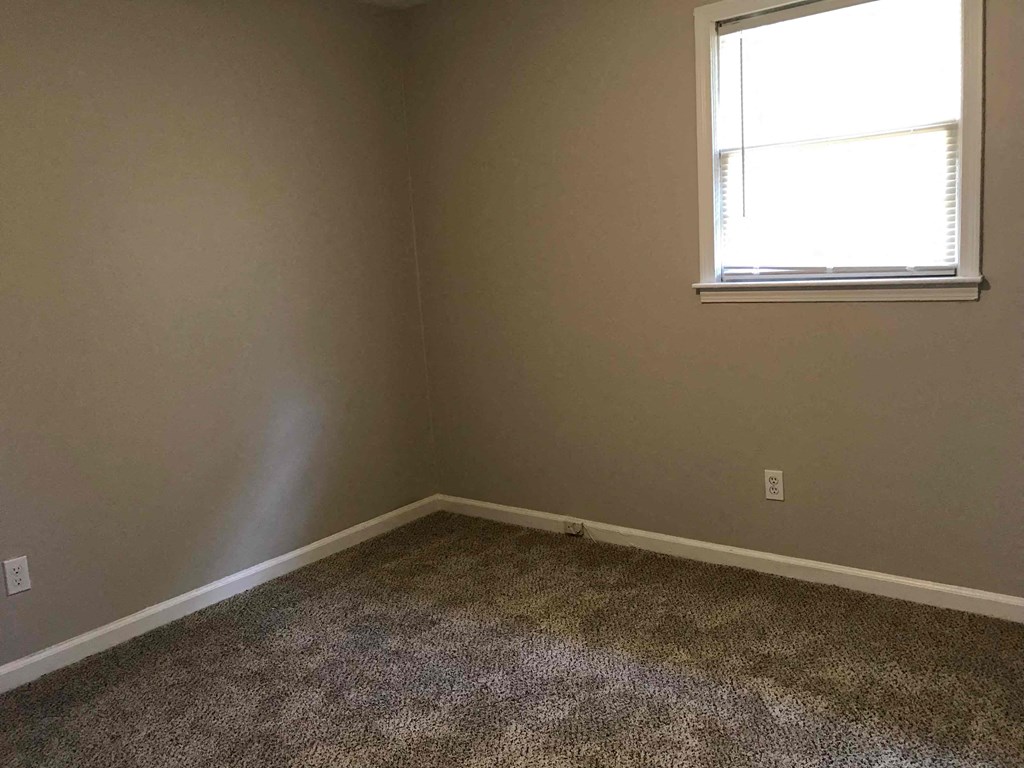a empty room with a window and carpet
