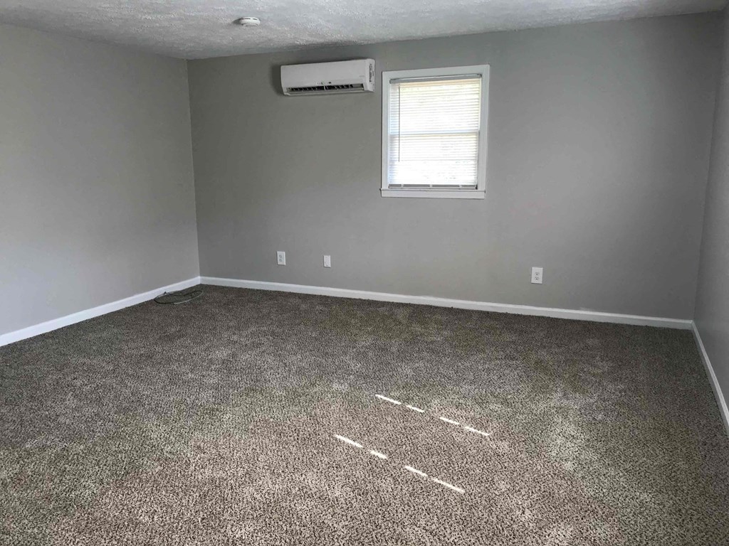 a empty room with carpet and a window