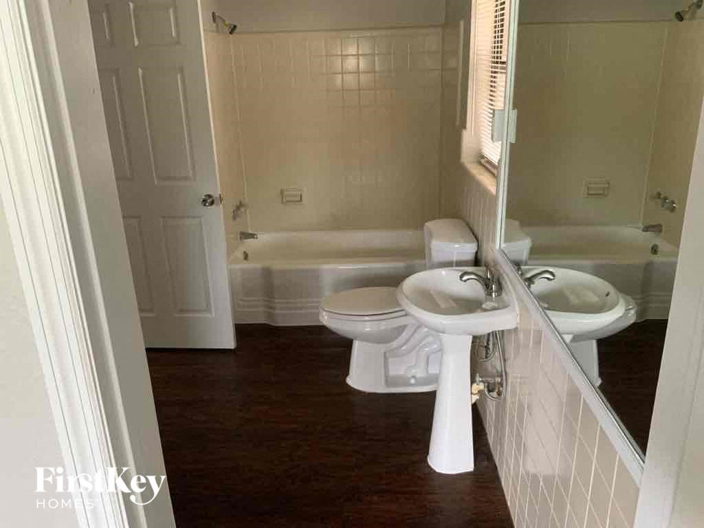 a bathroom with a toilet and a sink and a bath tub