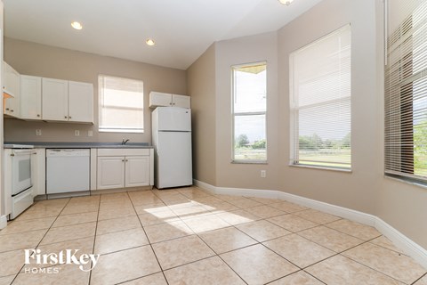 A kitchen with white appliances and cabinets is on the market.