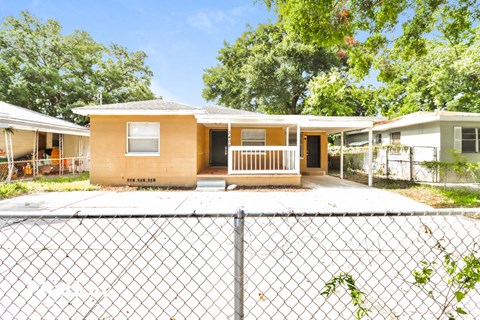 a small house with a fence in front of it