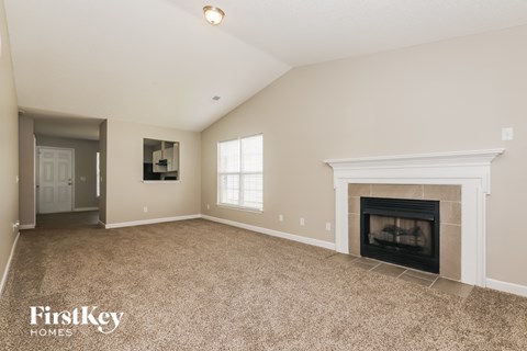 A spacious living room with a fireplace and a television.