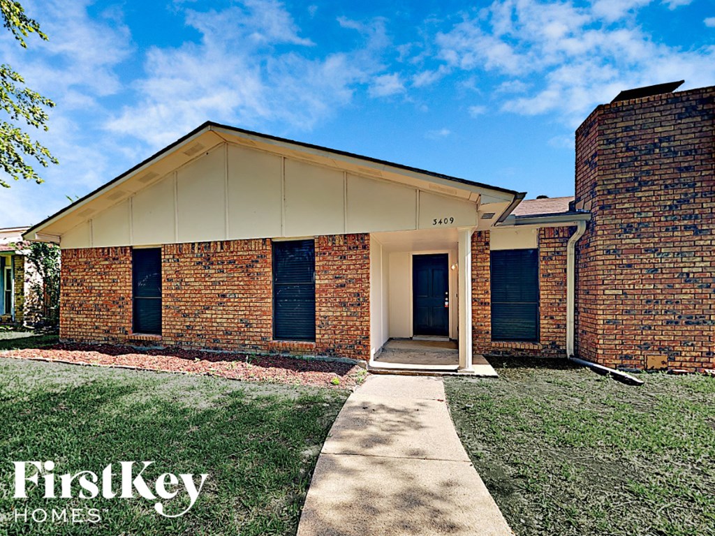 A brick house with a sign that says FirstKey Homes.