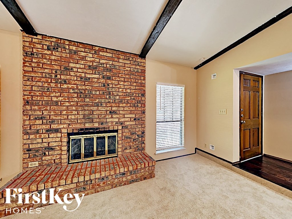 A room with a brick fireplace and a door.