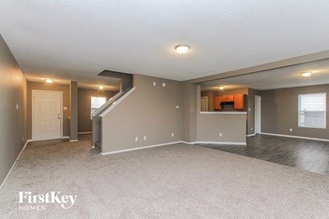 A spacious living room with a staircase leading to the upper level.