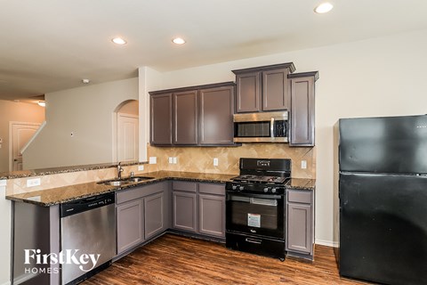 A kitchen with a black fridge and a black stove.