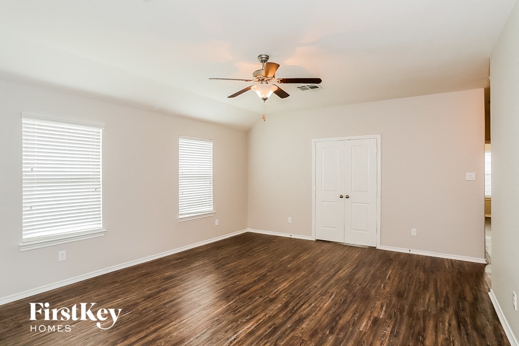 A room with wooden floors and a ceiling fan.