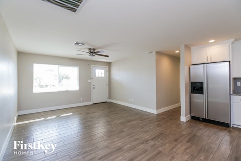 A spacious kitchen with wooden flooring and stainless steel appliances.