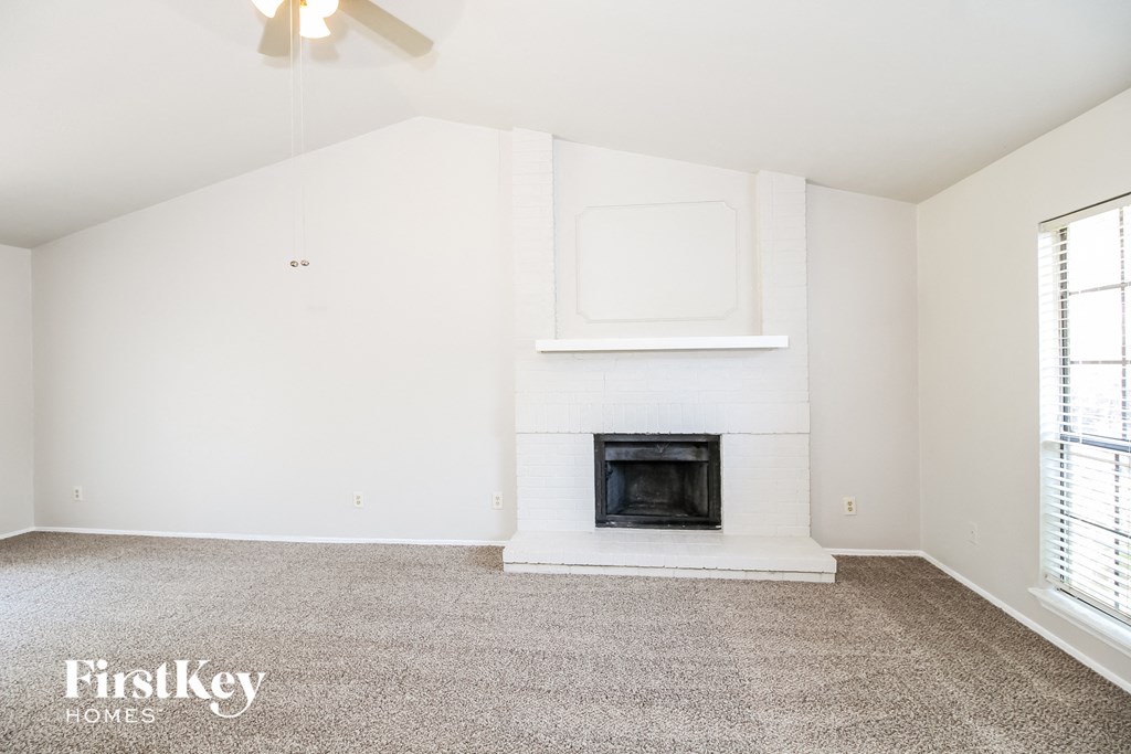 a living room with a fireplace and a carpeted floor