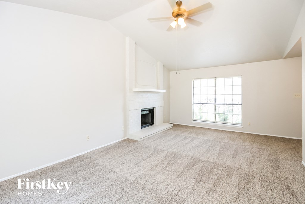 a living room with a fireplace and a ceiling fan