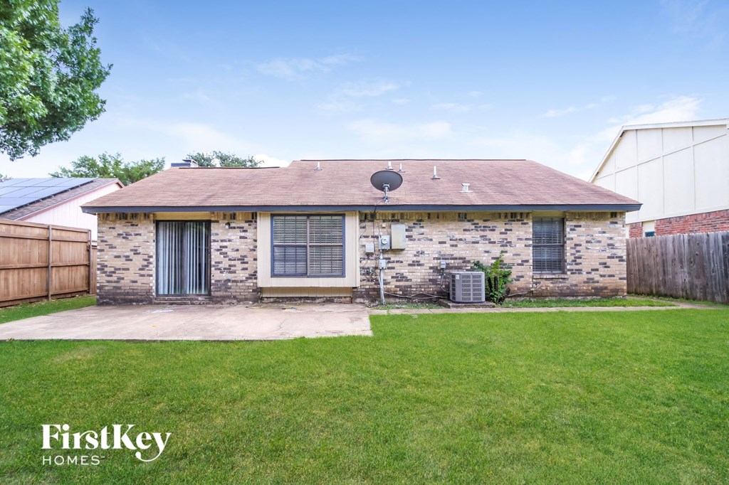 a small brick house with a yard and a satellite dish