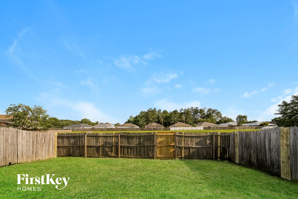a backyard with a fenced in area with grass and a fence