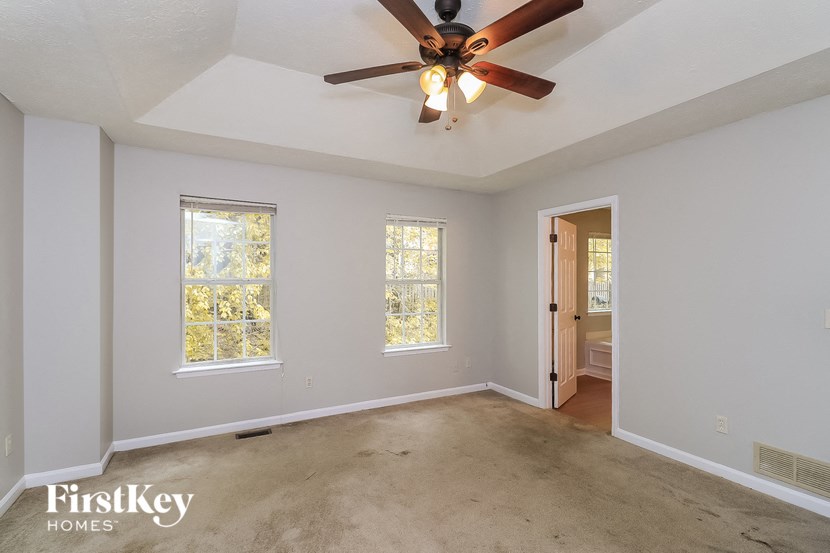 an empty living room with a ceiling fan