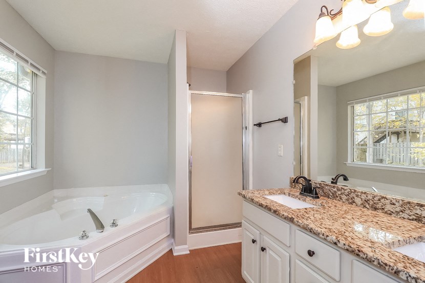 a bathroom with a tub and a sink and a mirror