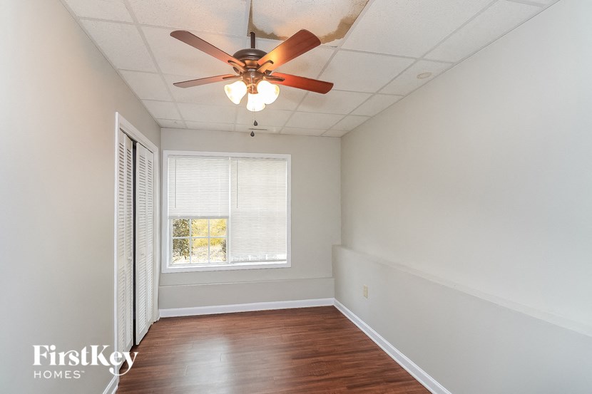 a empty room with a ceiling fan and a window