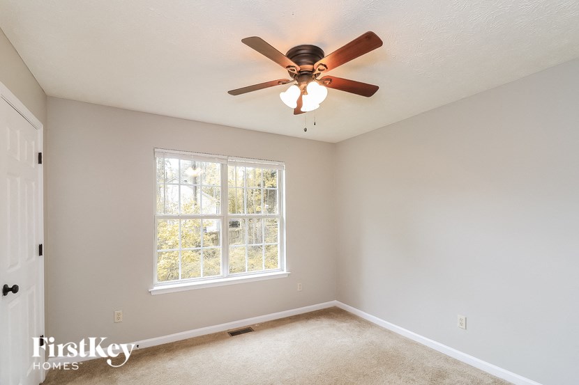 a bedroom with a ceiling fan and a window