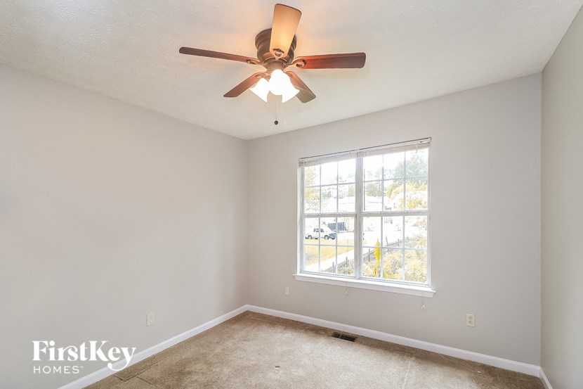 a bedroom with a ceiling fan and a window