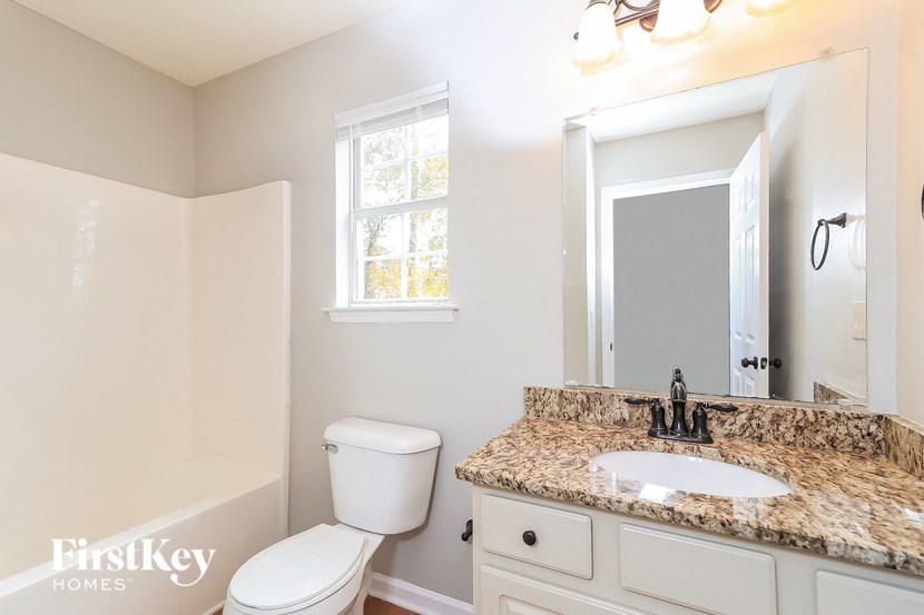 a bathroom with a toilet and a sink and a mirror