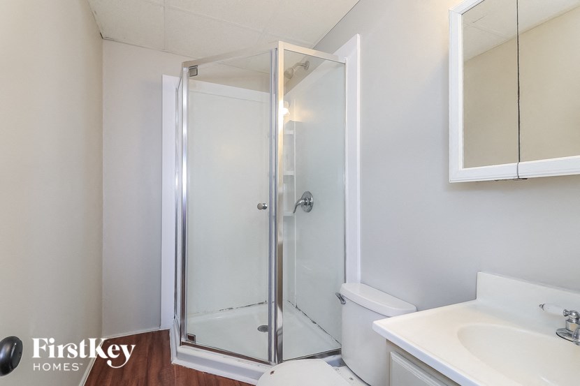 a bathroom with a shower and a sink and a toilet