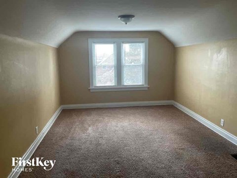 an empty room with carpet and a window