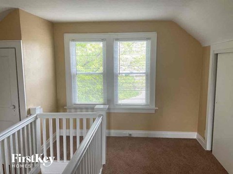 a room with a staircase and two windows
