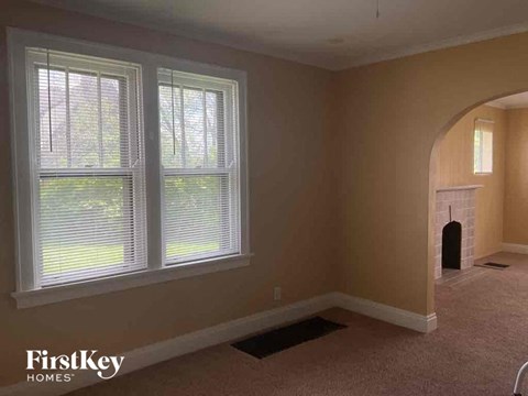 a living room with a fireplace and three windows