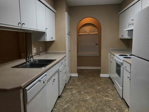 A kitchen with white cabinets and a sink.