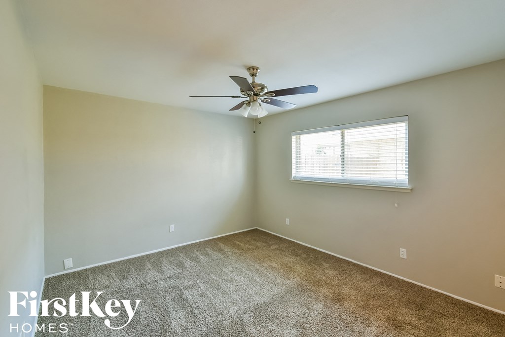 a bedroom with a ceiling fan and a window