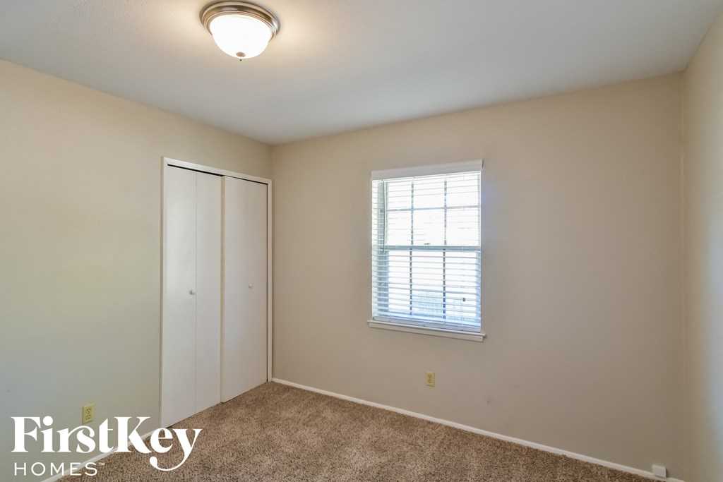 a bedroom with a closet and a window and a door